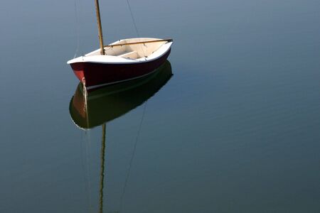 A small sailboat and its reflectionsの写真素材