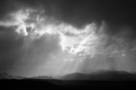 A dramatic sky over high desert hills in black and whiteの写真素材
