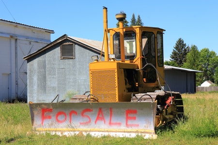 A small bulldozer with the words  For Sale  sprayed on the blade の写真素材