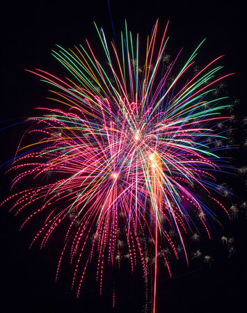 Multicolored bursts of fireworks against a black skyの写真素材