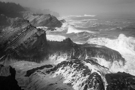 A dramatic black and white view of the Oregon Coast during stormy weatherの写真素材