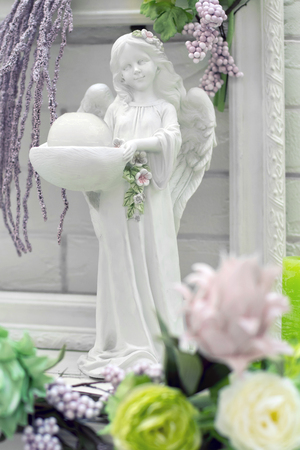 angel figurine in flowersの写真素材