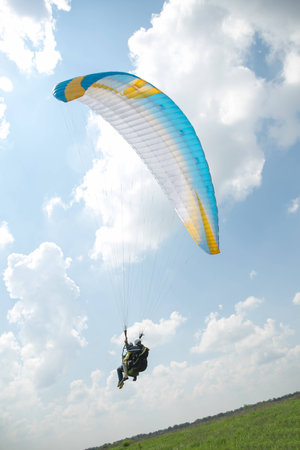 Paraglider in the blue sky, big blue cloudsの写真素材