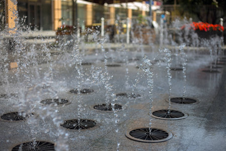 Splashes of water from a fountain in the summer in the city