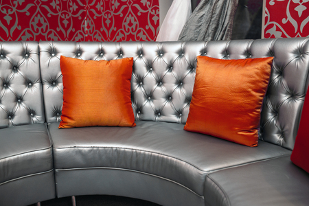 gray leather sofa with red pillowsの写真素材