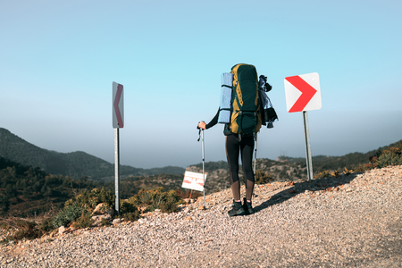 girl with a backpack in the mountains against the backdrop of the seaの写真素材