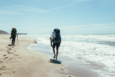 couple tourists walking on the beachの写真素材