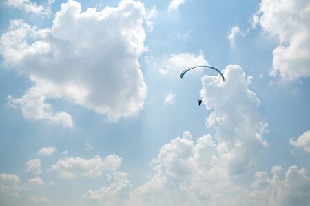 Paraglider in the blue sky, big blue cloudsの写真素材