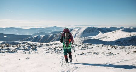 climber walking downhill in winterの写真素材