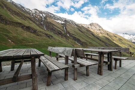 bench and bench on a stone floor against the backdrop of mountains with blue skyの写真素材