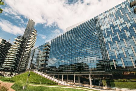 large glass building in the foreground green grass in the background blue sky and cloudの写真素材