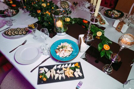 festive table decorated with leaves apricots grapefruits high glasses with gilding on a restaurant backgroundの写真素材
