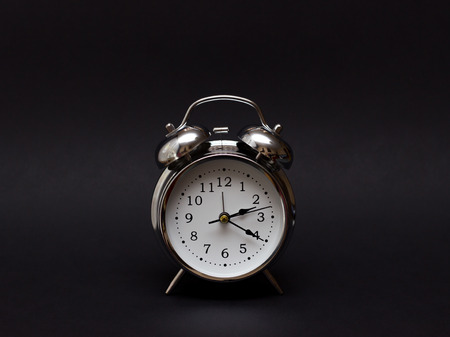 vintage alarm clock on black background.For time concept.