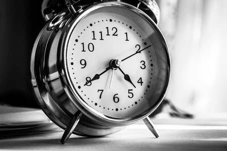 Black vintage alarm clock on black background.の写真素材