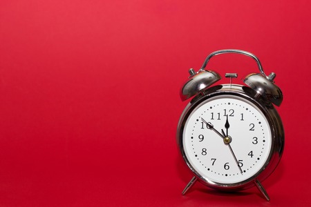 red alarm clock on red background. close up shot. top view. For time concept.の写真素材