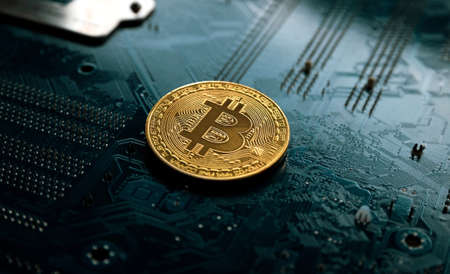 Gold and silver bitcoin on a dark background, on a printed circuit board. Cryptocurrency mining. background on your desktop or web banner.の写真素材