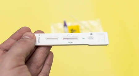 COVID 19, a man holding a negative antigen test in his hand, close-up.の写真素材