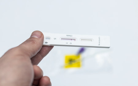 COVID 19, a man holding a negative antigen test in his hand, close-up.