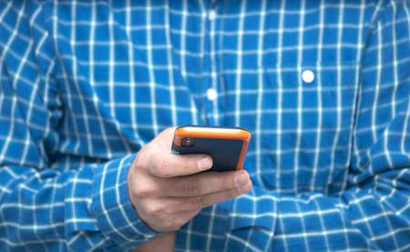 Hands of man typing text on mobile smartphone. Online chat chatting on application communication digital media website and social network.の写真素材
