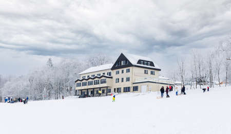 Winter landscape, a house in the snow on a hill, and people resting.のeditorial素材
