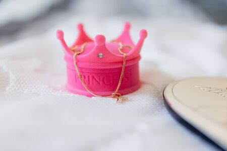 Gold cross with jewelry box in the form of a crown with a princess inscriptionの写真素材