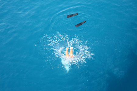 man jump into the water with splashes and flippersの写真素材