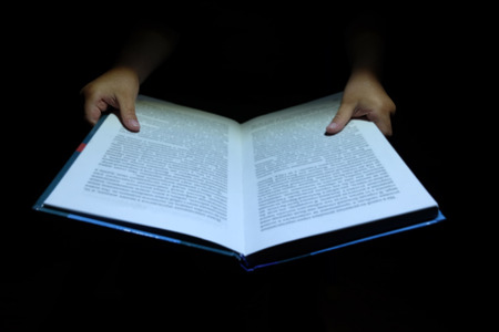 children's hands hold notebook book and reading