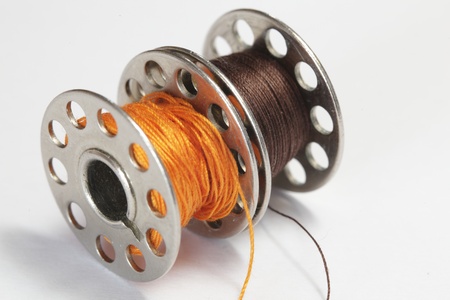 colorful threads over the white background on metal reelの写真素材
