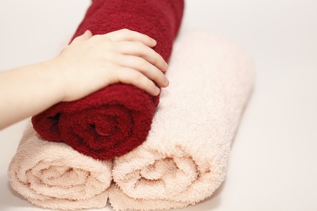 child hand holding on colored hand towelsの写真素材