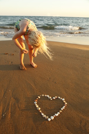 mussels heart at coast with young girlの写真素材