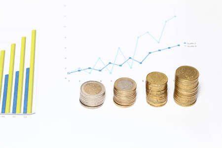 financial concept with euro coins and chartsの写真素材