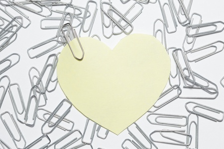 yellow heart sticker with many paper clipsの写真素材