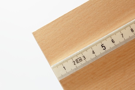 white measure in centimeters on a wooden plateの写真素材