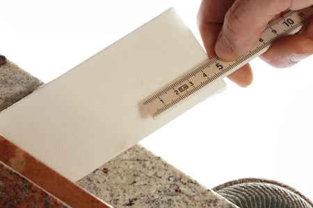 stones with tape measure in hand on white backgroundの写真素材