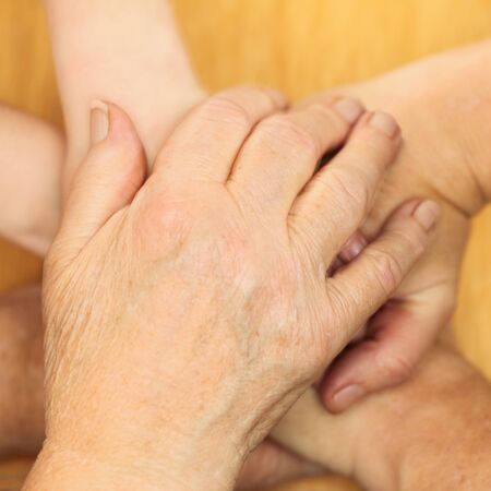 many different hands are forming a stack