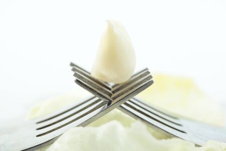 two forks crossed with garlic onwhiteの写真素材