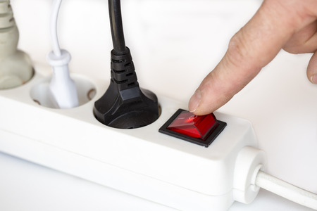 switch off with finger on white electric device