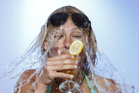 woman is drinking and gets a water shower
