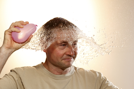 man with pink water ball and water splashの写真素材