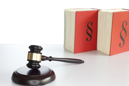 wooden gavel and books on grey table with white backgroundの写真素材