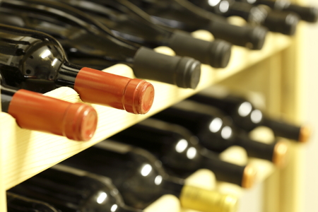 row of wine bottles in a wooden stack