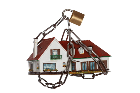 symbolic chain locked house on white backgroundの写真素材