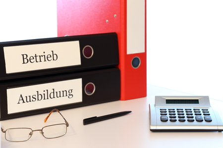 office desk with calculator and folders for educationの写真素材