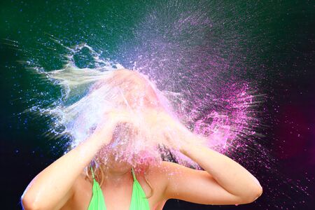 surprised young girl with powerful water splashの写真素材