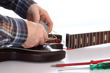 worker is repairing an old electric guitarの写真素材
