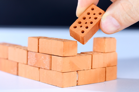 put in the last brick on a brick wallの写真素材