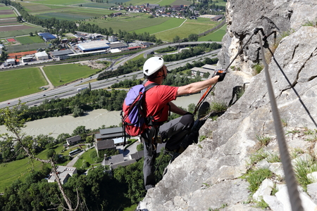 climbing up man on a rope way in alpsの写真素材