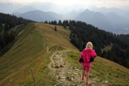 girl is going down on a small mountain pathの写真素材