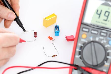 worker is testing a resistor on his workplace