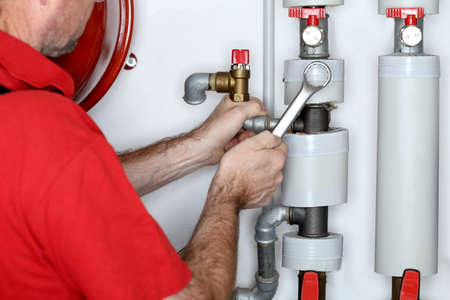 plumber with metal wrench in hand is working